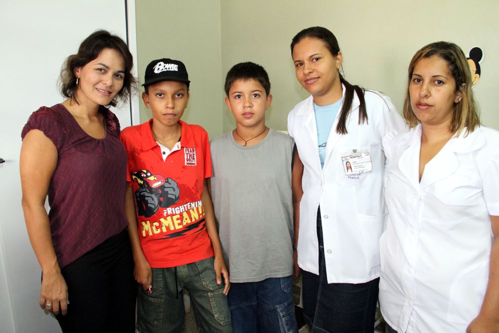 Diretora da Atenção Básica, Liége Tada, com funcionárias e usuários da unidade de saúde da COHAB