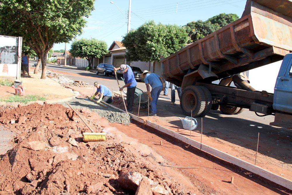 A foto destaca os funcionários municipais trabalhando na construção da canaleta de concreto