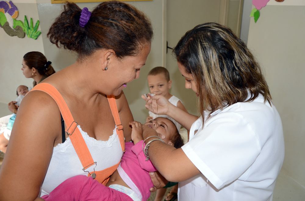 Criança recebendo a dose da vacina contra a paralisia infantil